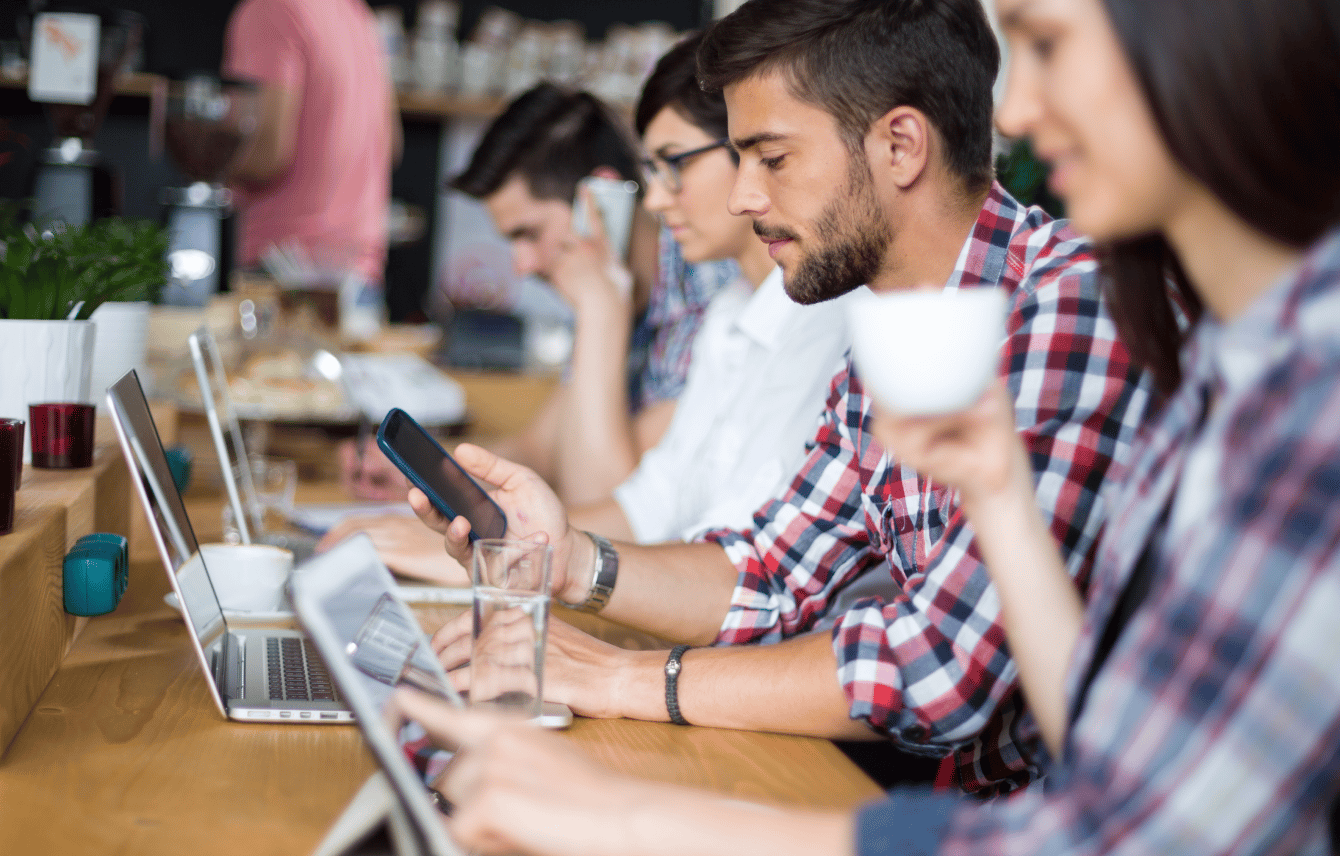 People working remotely on computers in a coffee shop